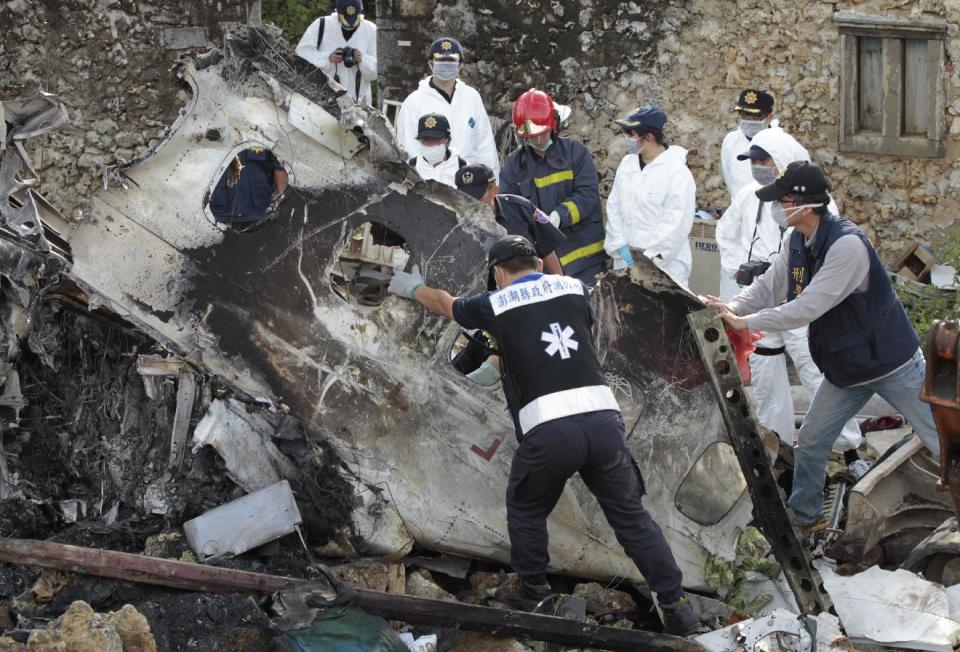 A forensic team recovers human remains among the wreckage of crashed TransAsia Airways flight GE222 on the outlying island of Penghu, Taiwan, Thursday, July 24, 2014. Stormy weather on the trailing edge of Typhoon Matmo was the likely cause of the plane crash that killed more than 40 people, the airline said Thursday. (AP Photo/Wally Santana)