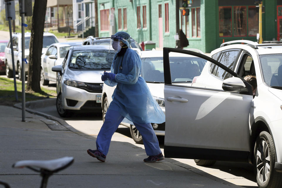A health worker finishes a drive-up test on a driver at People's Center Monday, April 27, 2020, in Minneapolis during expanded coronavirus testing as Minnesota Gov. Tim Walz tries to get the numbers of tests up. (AP Photo/Jim Mone)