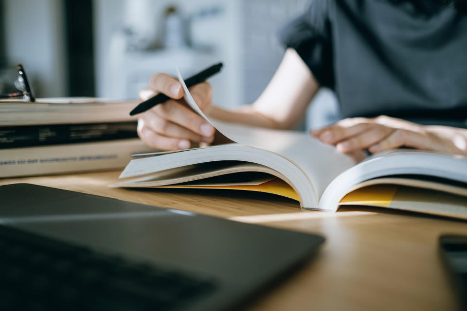 Person studying with open books and laptop on a desk