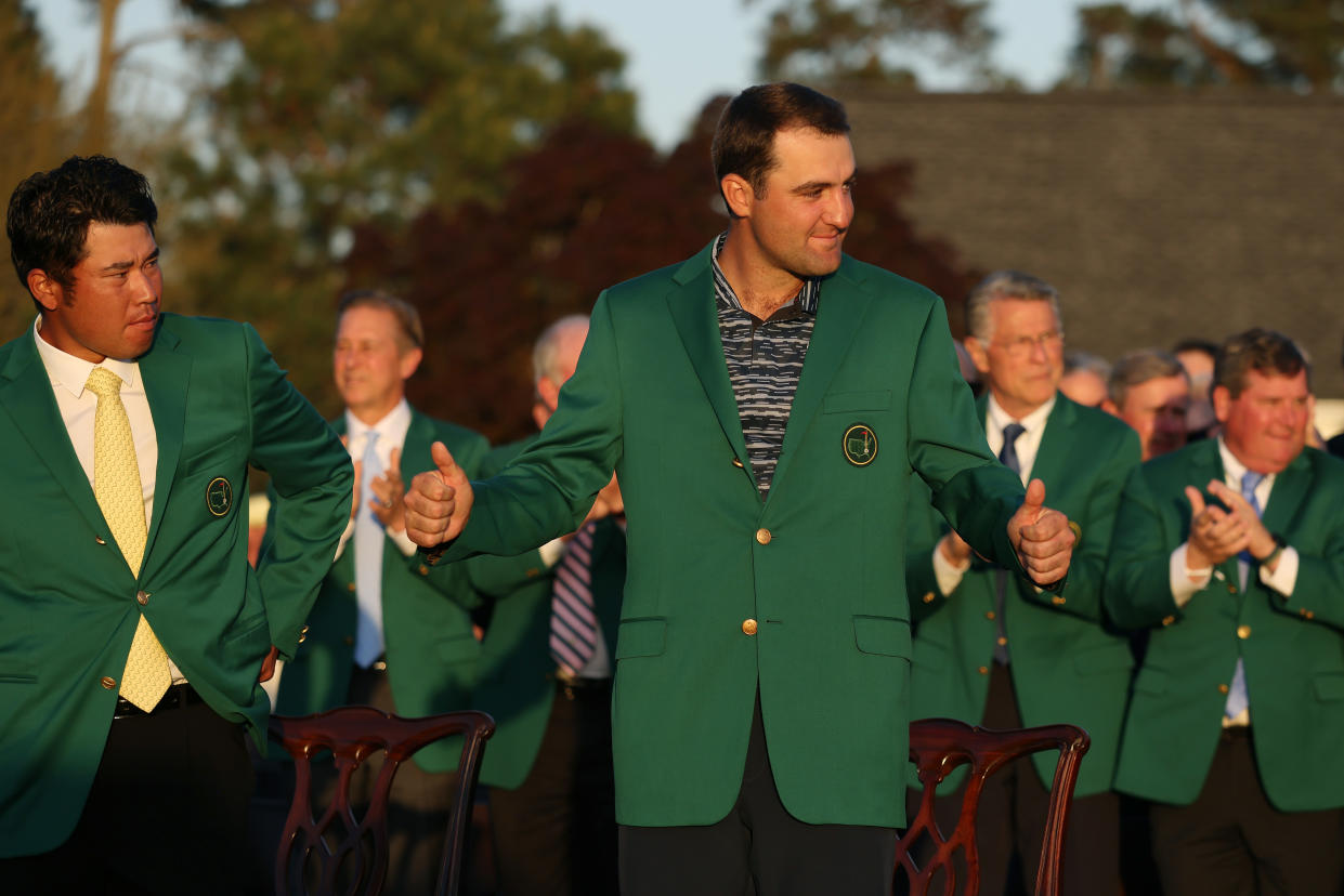 Scottie Scheffler (center) celebrates after being awarded a green jacket by 2021 Masters champion Hideki Matsuyama (left) during the green jacket ceremony after Scheffler won the Masters at Augusta National Golf Club on April 10, 2022. (Photo by Gregory Shamus/Getty Images)