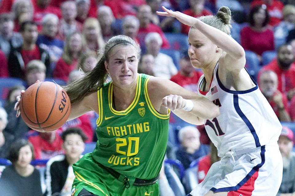 Oregon guard Sabrina Ionescu (20) drives around Arizona guard Mara Mote during the first half of an NCAA college basketball game Sunday, Jan. 12, 2020, in Tucson, Ariz. (AP Photo/Rick Scuteri)