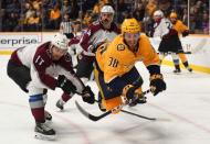 Nov 27, 2018; Nashville, TN, USA; Nashville Predators right wing Ryan Hartman (38) is tripped by Colorado Avalanche center Tyson Jost (17) as he battles for a puck during the third period at Bridgestone Arena. Mandatory Credit: Christopher Hanewinckel-USA TODAY Sports