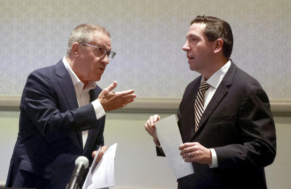 Central Florida Tourism Oversight District Board of Supervisors chairman Martin Garcia, left, consults with board member Brian Aungst, Jr., before the passing of a resolution to invalidate Disney's final agreement with the previous board —the Reedy Creek Improvement District— Wednesday, April 26, 2023, in Lake Buena Vista, Fla. Florida Gov. Ron DeSantis handpicked the new board in an ongoing dispute with Disney Co. over who controls the special taxing district that manages the municipal infrastructure at Walt Disney World. (Joe Burbank/Orlando Sentinel via AP)