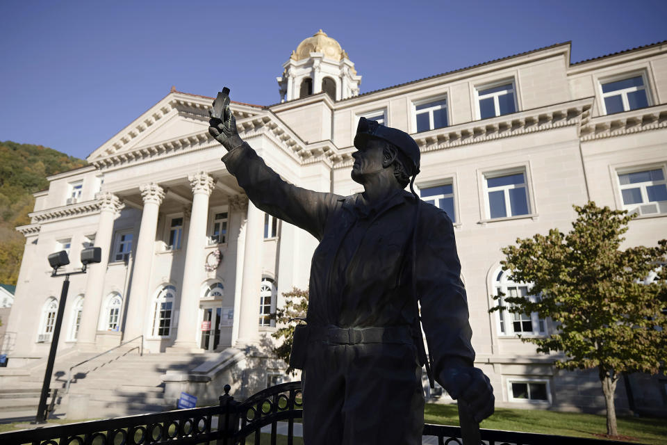 A statue of a coal miner stands in front of the Boone County Courthouse in Madison, W.Va., on Tuesday, Oct. 13, 2020. Four years after Donald Trump donned a miner’s helmet at a West Virginia campaign rally and vowed to save a dying industry, coal has not come roaring back. The fuel has been outmatched against cheaper, cleaner natural gas and renewable energy. But many West Virginians applaud Trump's efforts and remain loyal as he seeks a second term. (AP Photo/Chris Jackson)