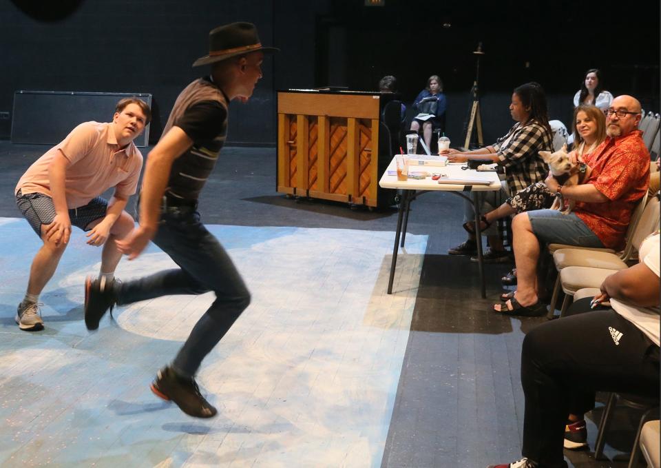 Director Warren Scott Friedman and his dog, Beau, watch as cast members rehearse for the high school All-City production of "Oklahoma!"