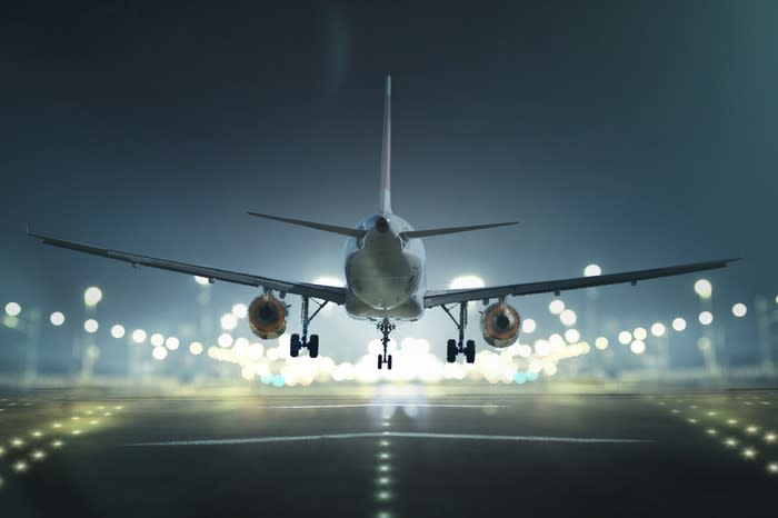 An airplane coming in for a landing at night.