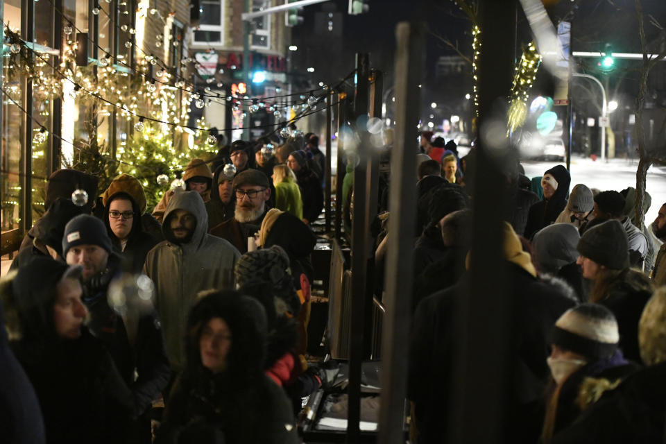 A long line of people brave the cold as they wait to be the first in Illinois to purchase recreational marijuana at Sunnyside dispensary Wednesday, Jan. 1, 2020, in Chicago. (AP Photo/Paul Beaty)