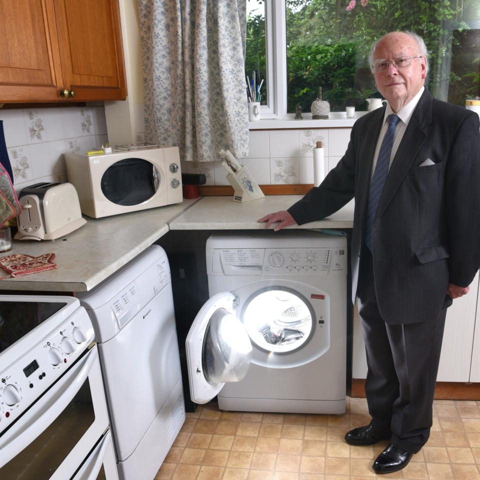 Picture shows Royston Lewis at home in Wales stood next to the washing machine which has not been used for seven years - Credit: Jay Williams