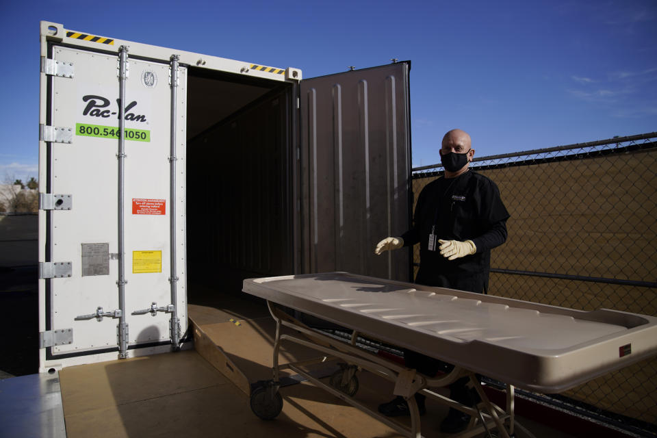 FILE - In this Jan. 8, 2021, file photo, Michael Murphy, a consultant serving as interim Clark County coroner, gives a tour of a refrigerated trailer at the coroner's office in Las Vegas. As in other cities, some overwhelmed funeral homes have used refrigerated trailers to hold the dead, Murphy said. (AP Photo/John Locher, File)