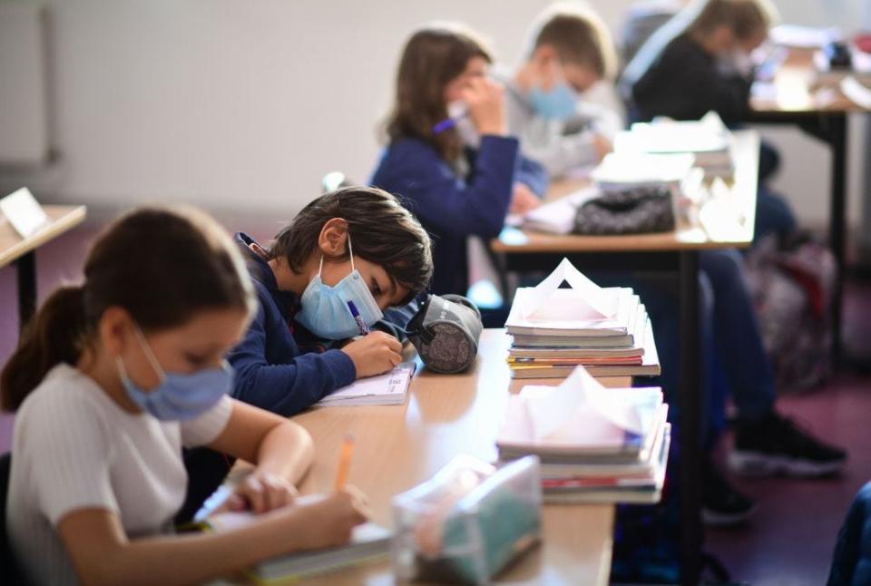 TOPSHOT - Pupils wearing protective masks write during a class at FranÃ§oise-Giroud middle school in Vincennes, east of Paris, on September 1, 2020, on the first day of the school year amid the Covid-19 epidemic. - French pupils go back to school on September 1 as schools across Europe open their doors to greet returning pupils this month, nearly six months after the coronavirus outbreak forced them to close and despite rising infection rates across the continent. (Photo by Martin BUREAU / AFP) (Photo by MARTIN BUREAU/AFP via Getty Images)