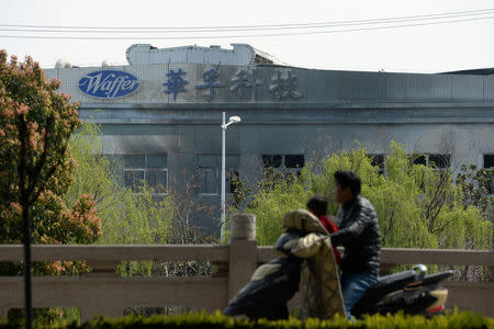 A man drives a motorbike past a damaged building of a metal-molding plant owned by Kunshan Waffer Technology Co following an explosion in Kunshan, Jiangsu province, China March 31, 2019. REUTERS/Stringer