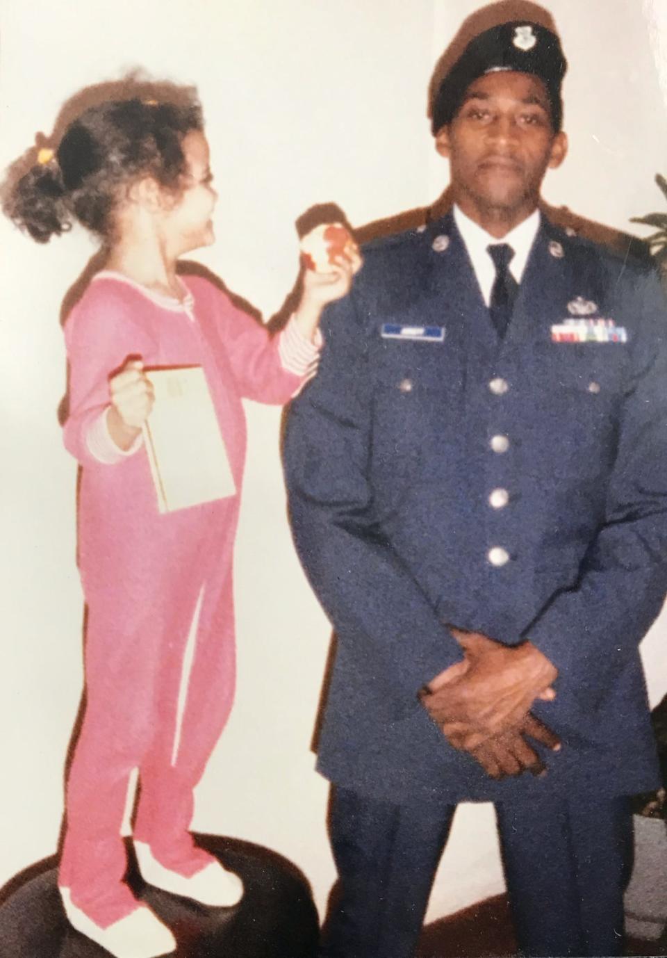 Tomitka Jurnett-Stewart at four years old trying to give an apple to her father, Tommy Jurnett.