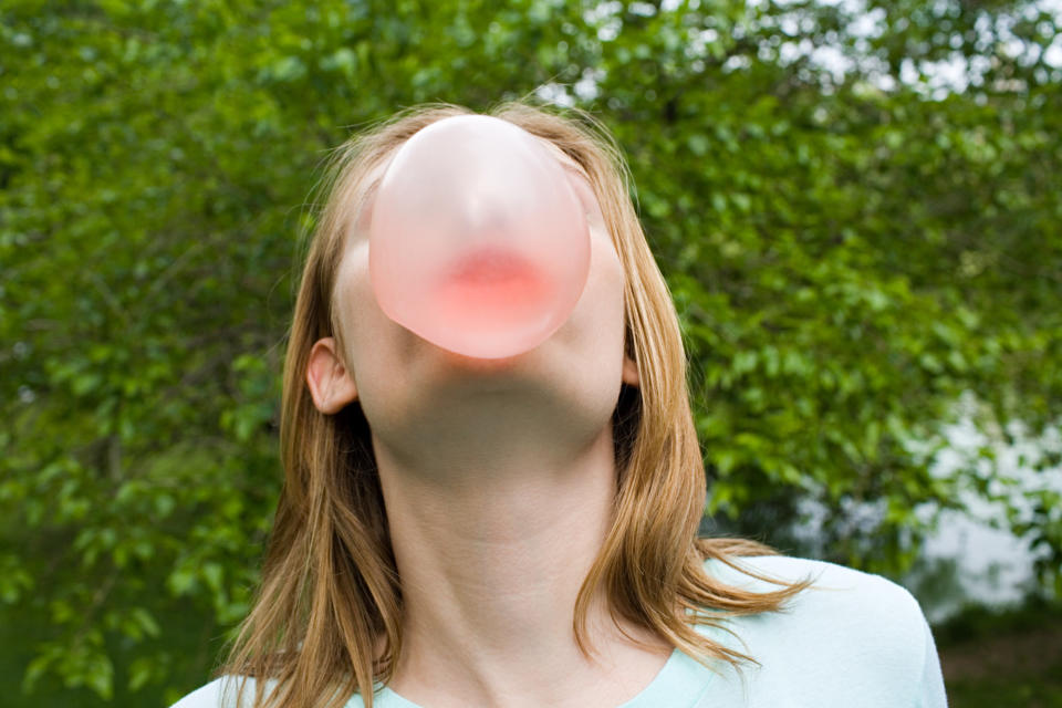 A person blowing a bubble with gum