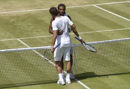 Viktor Troicki of Serbia embraces Dustin Brown of Germany after winning their match at the Wimbledon Tennis Championships in London, July 4, 2015. REUTERS/Toby Melville