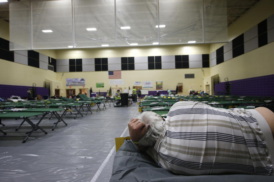 An evacuee lies on a cot at an evacuation shelter for people with special needs, in preparation for Hurricane Dorian, at Dr. David L. Anderson Middle School in Stuart, Fla., Sunday, Sept. 1, 2019. Some coastal areas are under a mandatory evacuation since the path of the storm is still uncertain. (AP Photo/Gerald Herbert)