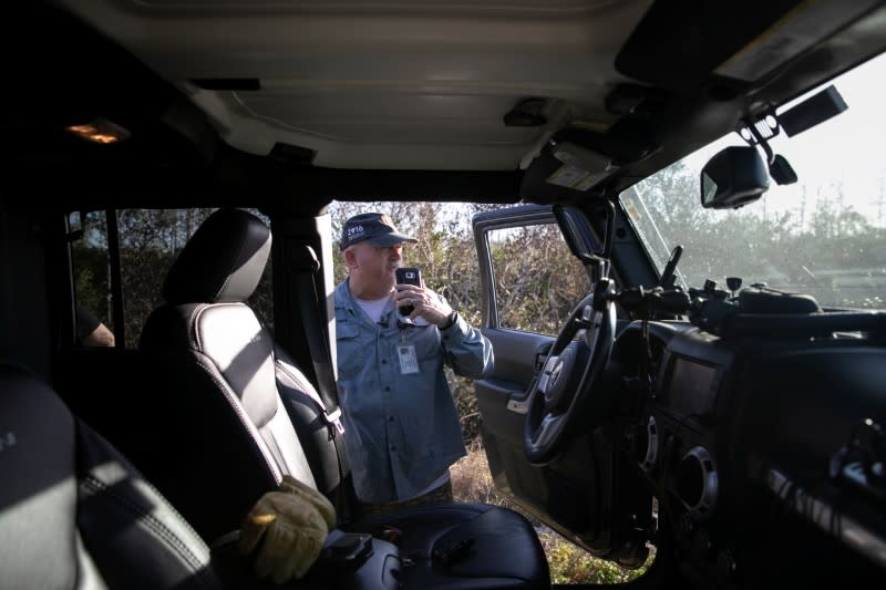 Thomas Aycock talks on his phone as he hunts Burmese pythons, in the Everglades' swamps, near Ochopee