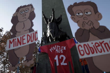 Teachers hold a t-shirt in the likeness of the Chilean soccer team jersey during a demonstration march to demand changes in the education system in Santiago, Chile July 3, 2015. REUTERS/Ueslei Marcelino