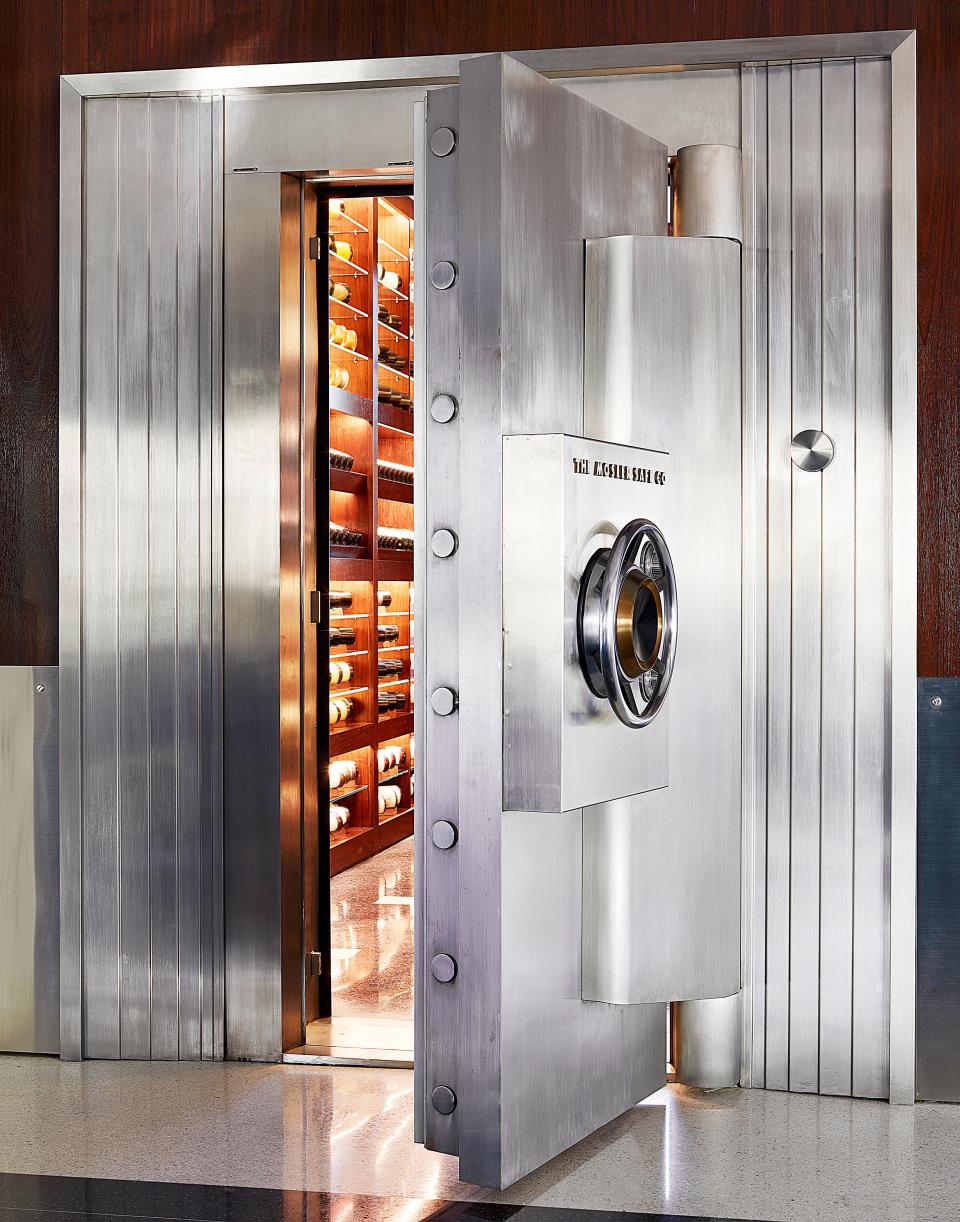 A vintage bank-vault door opens into the wine-storage room.