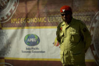 A security official stands guard outside a perimeter fence for a secured area ahead of the APEC Economic Leaders' Week Summit in Port Moresby, Papua New Guinea, Wednesday, Nov. 14, 2018. After three decades of promoting free trade as a panacea to poverty, the APEC grouping of nations that includes the U.S. and China is holding its lavish annual leaders meeting in the country that can least afford it. (AP Photo/Mark Schiefelbein)