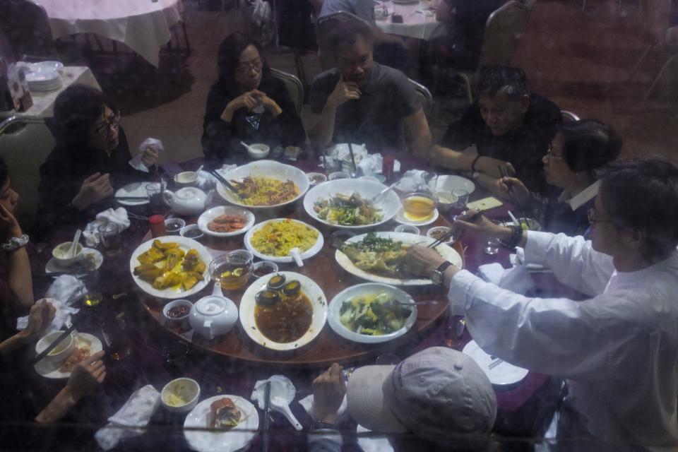 Customers eat abalone from South Africa in Hong Kong, Saturday, April 22, 2023. (AP Photo/Louise Delmotte)