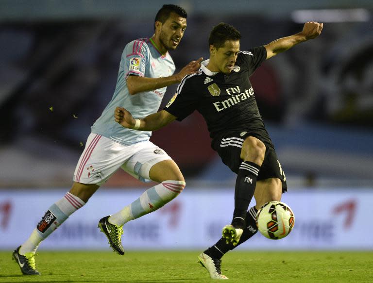 Real Madrid's forward Javier Hernandez (R) scores a goal next to Celta's defender Gustavo Cabral during the Spanish league football match in Vigo on April 26, 2015