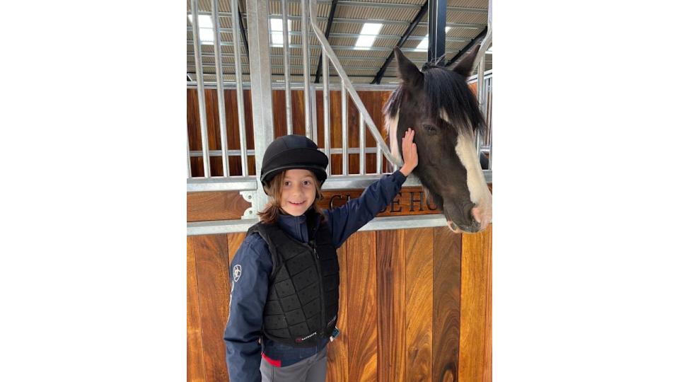 Olivia in horseriding gear with horse