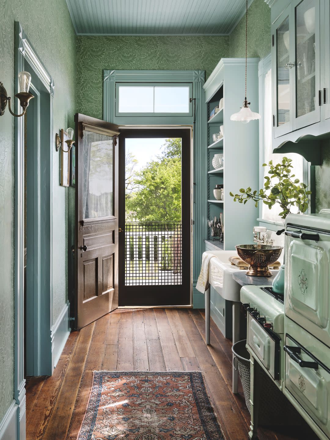 nostalgic farmhouse kitchen with blue cabinetry and wallpaper