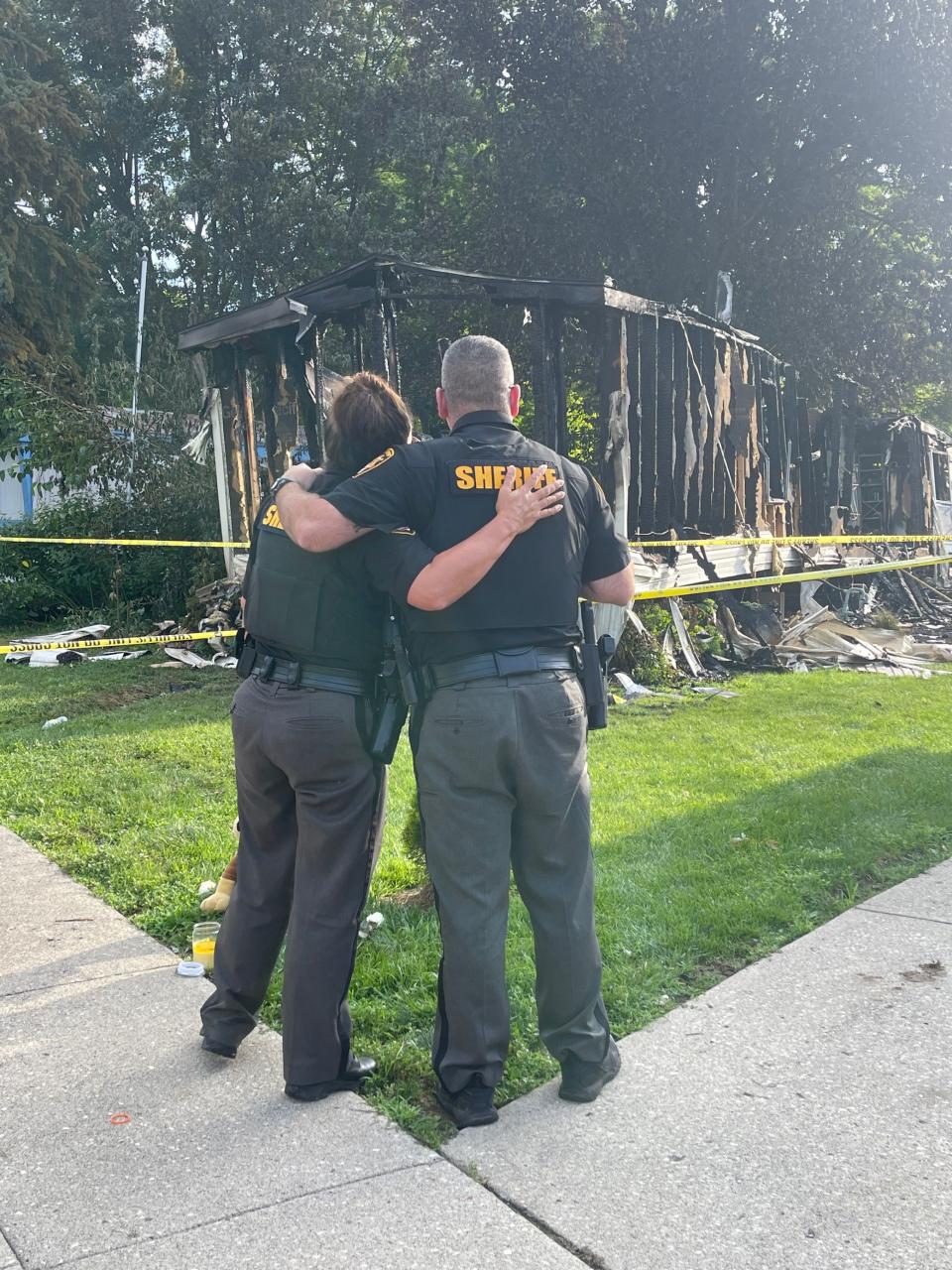 Investigators returned to the scene of a mobile home park in Clark County the day after a Clark County deputy was shot and later died from his injuries. A memorial outside the house has started to grow with two deputies arriving at the scene and placing flowers outside the house. (Gabrielle Enright/Staff)