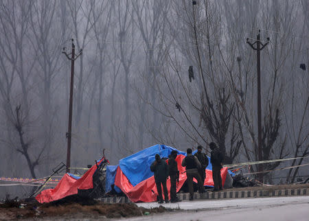 FILE PHOTO: Forensic and security officials stand next to the wreckage of a bus after a suicide bomber rammed a car into the bus carrying Central Reserve Police Force (CRPF) personnel on Thursday, in Lethpora in south Kashmir's Pulwama district, February 15, 2019. REUTERS/Danish Ismail/File Photo