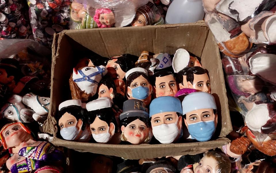 Masks for making Tanta Wawas (bread children) in honor of the victims of the coronavirus disease (COVID-19) are displayed at a market - DAVID MERCADO / REUTERS