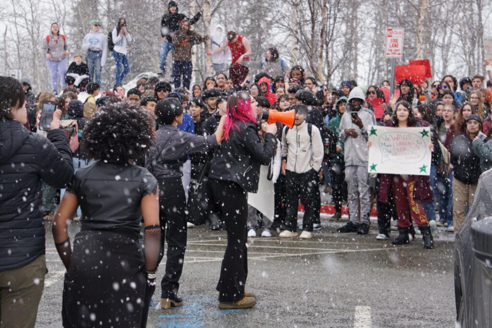 Liberty Lee, a sophomore at West Anchorage High School, rallies students who gathered in the spring snow on April 4, 2024, to protest Gov. Mike Dunleavy's veto of school funding. (Photo by Yereth Rosen/Alaska Beacon)