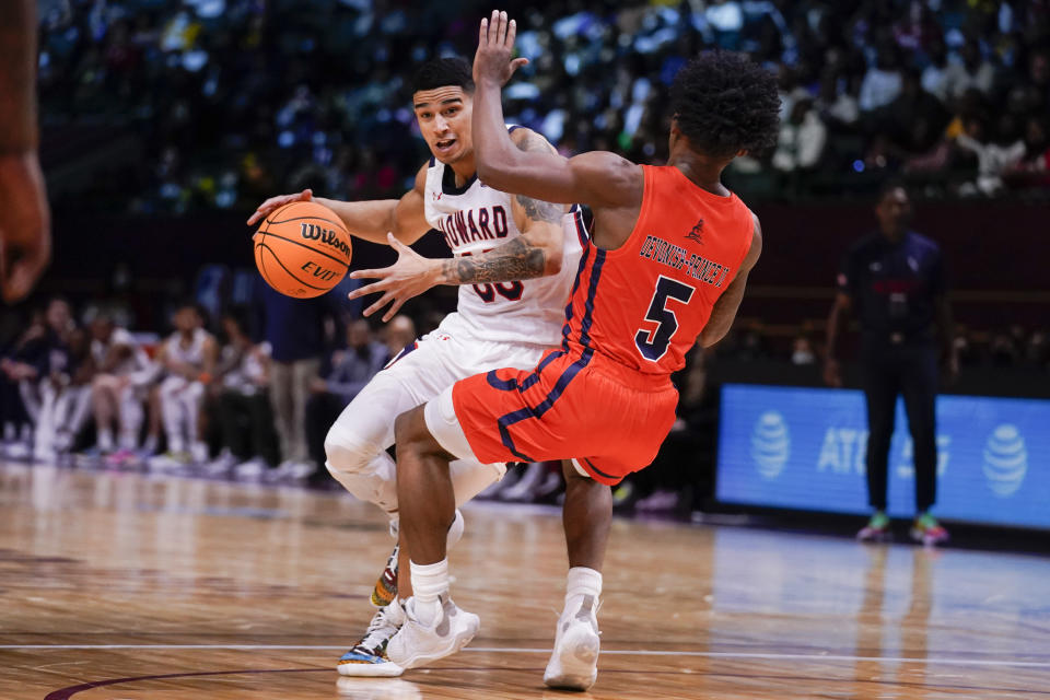 Howard's Tai Bibbs, left, drives on Morgan State's Sherwyn Devonish (5) during the first half of the HBCU Classic NCAA college basketball game, part of the NBA All-Star game weekend, Saturday, Feb. 19, 2022, in Cleveland. (AP Photo/Charles Krupa)