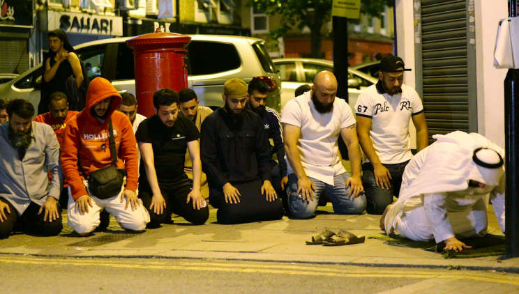 Locals observe prayers at the scene of the attack (PA)