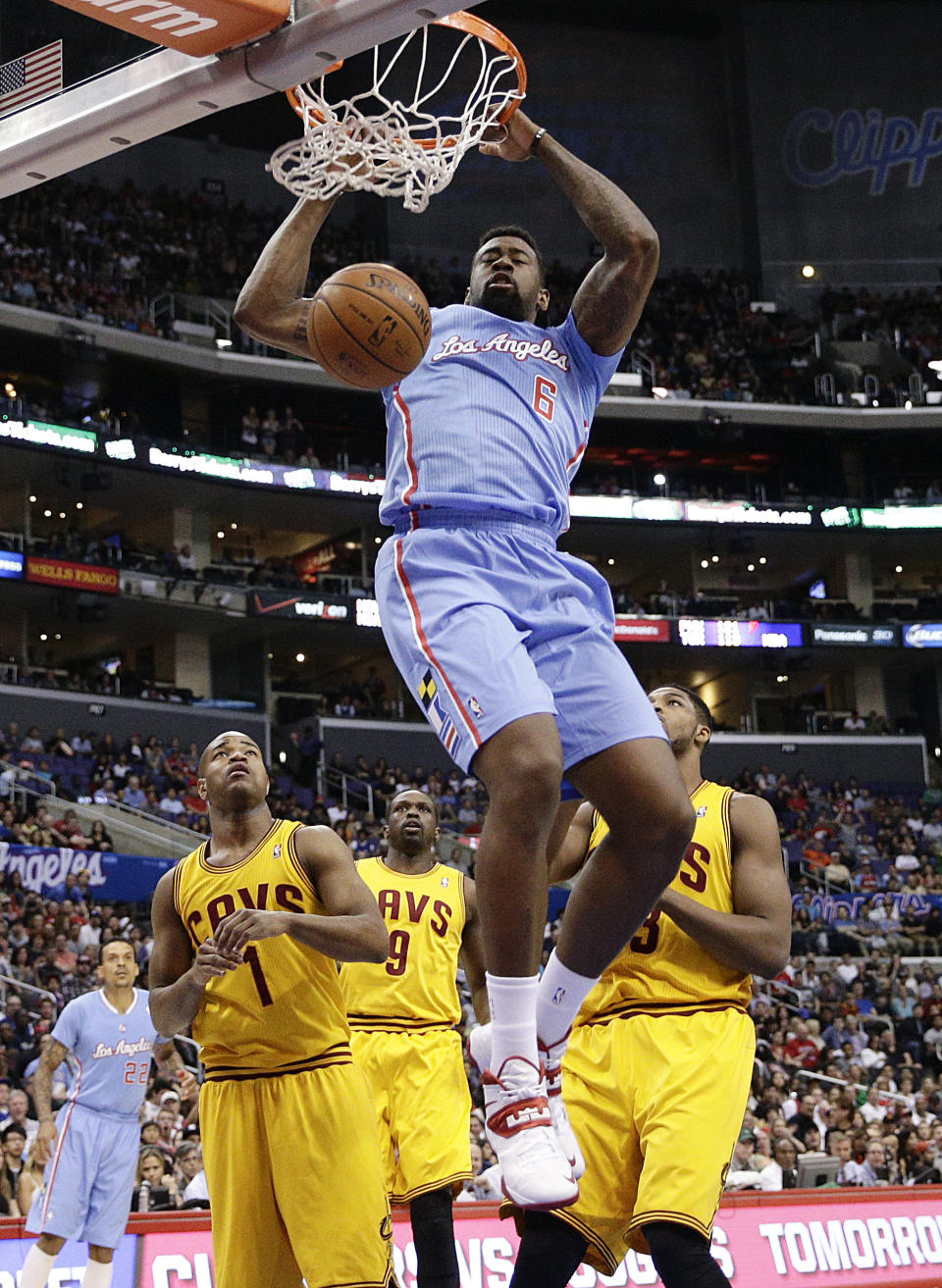 Los Angeles Clippers's DeAndre Jordan, top, makes a dunk as Cleveland Cavaliers's Jarrett Jack, left, and Tristan Thompson, right, watch during the first half of an NBA basketball game on Sunday, March 16, 2014, in Los Angeles. (AP Photo/Jae C. Hong)