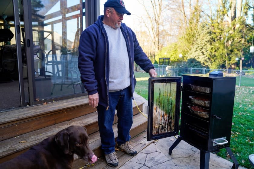 Kevin Barthold checks his smoker at his home in Canton on Election Day