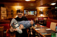 Adi’s sister, Nicoleta, 34, carries her niece Elena, who is two years and seven-months old, in a restaurant after a trip to the Venture Wildlife Park near London, Britain, February 12, 2019. REUTERS/Alecsandra Dragoi