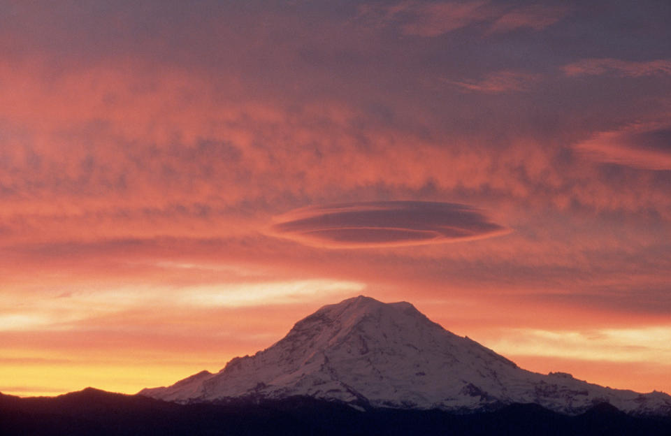 A lenticular cloud floats over Mount Rainier at sunrise. Washington, USA.