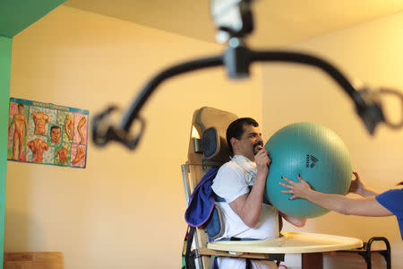 Joey smiles while receiving physical therapy at the Abriendo Puertas al Futuro (Opening Doors to the Future) day center in Bayamon, Puerto Rico, December 2, 2016. REUTERS/Alvin Baez