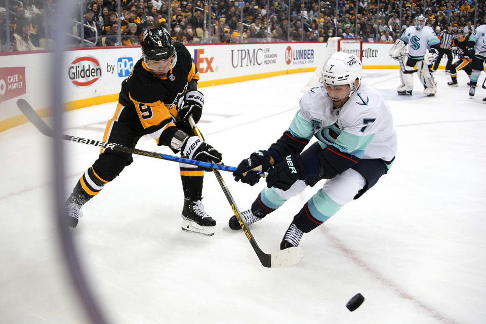 Pittsburgh Penguins' Evan Rodrigues (9) works the puck around the corner with Seattle Kraken's Jordan Eberle (7) defending during the second period of an NHL hockey game in Pittsburgh, Thursday, Jan. 27, 2022. (AP Photo/Gene J. Puskar)