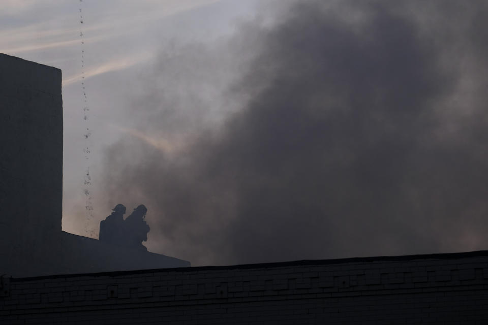 Los Angeles Fire Department firefighters work the scene of a structure fire that injured multiple firefighters, according to a fire department spokesman, Saturday, May 16, 2020, in Los Angeles. (AP Photo/Ringo H.W. Chiu)