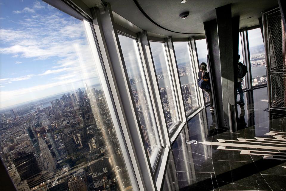 People look at the view from the renovated 102nd-floor observatory of the Empire State Building.