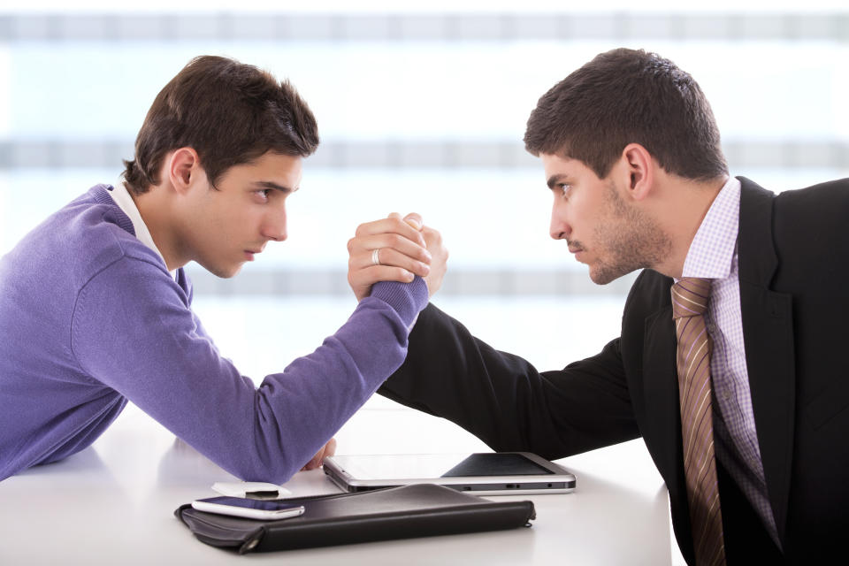 Two men arm wrestling.