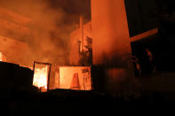 <p>Locals try to extinguish a fire at a nearby house as a wildfire burns at the village of Mati, near Athens, Greece, July 23, 2018. (Photo: Alkis Konstantinidis/Reuters) </p>