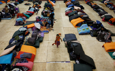 A migrant boy, part of a caravan of thousands traveling from Central America en route to the United States, runs while holding a toy at a temporary shelter in Tijuana, Mexico November 22, 2018. REUTERS/Kim Kyung-Hoon