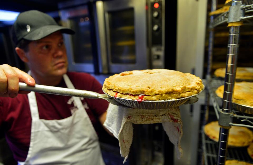 Yoder's Restaurant in Sarasota was busy with their annual Thanksgiving pie-making assembly lines. By Tuesday the staff had made nearly 4000 pies and according to restaurant manager Brian Emrich, off camera, he looking to sell a record setting 7,000 pies this year. Here Yoder's bakery manager Steve Hochstetler moves pies to the cooling area.  (November 25, 2014) (Herald-Tribune staff photo by Thomas Bender)