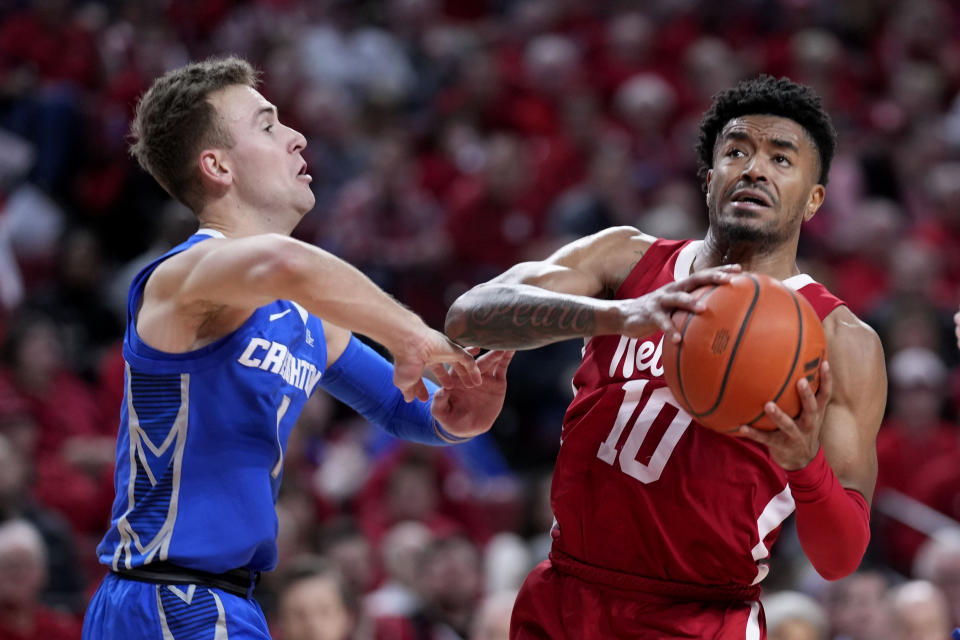 Nebraska guard Jamarques Lawrence (10) drives to the basket past Creighton guard Steven Ashworth, left, during the first half of an NCAA college basketball game, Sunday, Dec. 3, 2023, in Lincoln, Neb. (AP Photo/Charlie Neibergall)