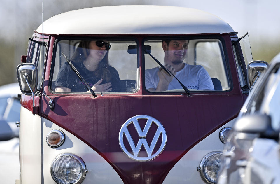 Believers pray in a old Volkswagen bus during a Good Friday church service at a drive-in cinema when all German churches are closed for worships due to the coronavirus outbreak in Duesseldorf, Germany, Friday, April 10, 2020. (AP Photo/Martin Meissner)