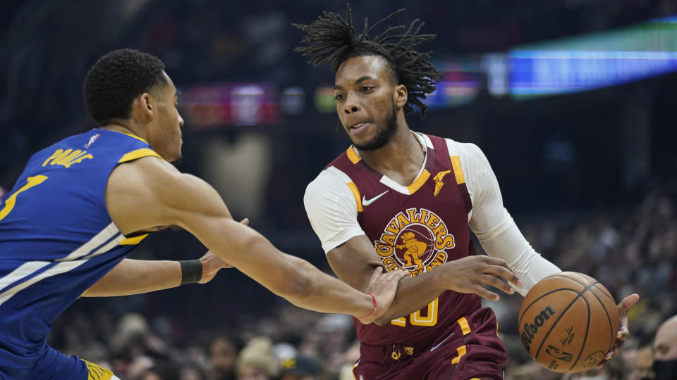 Cleveland Cavaliers' Darius Garland (10) drives past Golden State Warriors' Jordan Poole (3) in the first half of an NBA basketball game, Thursday, Nov. 18, 2021, in Cleveland. (AP Photo/Tony Dejak)