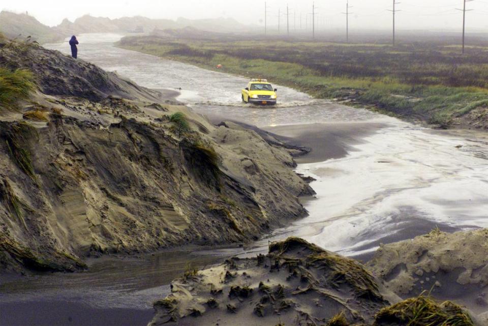 A N.C. Division of Highways truck makes its way through water and sand washed onto Highway 12. Heavy surf made cuts through the dune line such as the cut at lower left, blocking several miles of the road. Southern Hatteras Island communities of Buxton and Rodanthe were cut-off due to the closure.