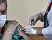 FILE - In this Feb. 23, 2021, file photo, a medical worker administers a shot of COVID-19 vaccine to a man in Podgorica, Montenegro. Montenegro has launched vaccinations against the coronavirus with doses of Russia's Sputnik V vaccines that were donated by neighboring Serbia. Russia’s boast in August that it was the first country to authorize a coronavirus vaccine led to skepticism because of its insufficient testing on only a few dozen people. Now, with demand growing for the Sputnik V, experts are raising questions again, this time over whether Moscow can keep up with all the orders from countries that want it. (AP Photo/Risto Bozovic, File)